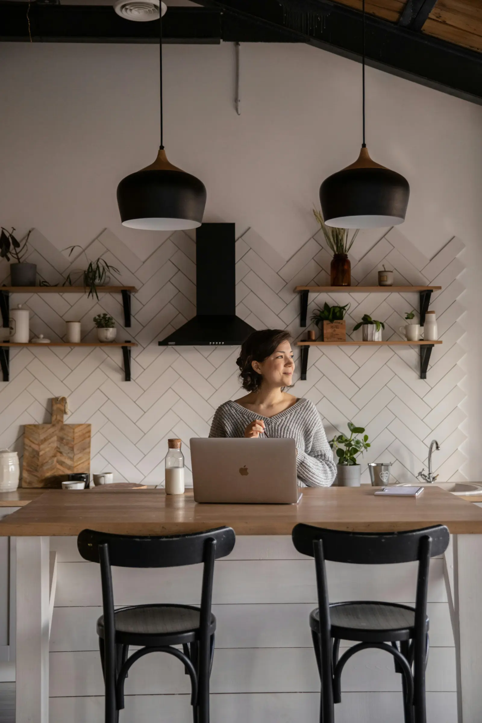 A team member working on a laptop from a cosy kitchen